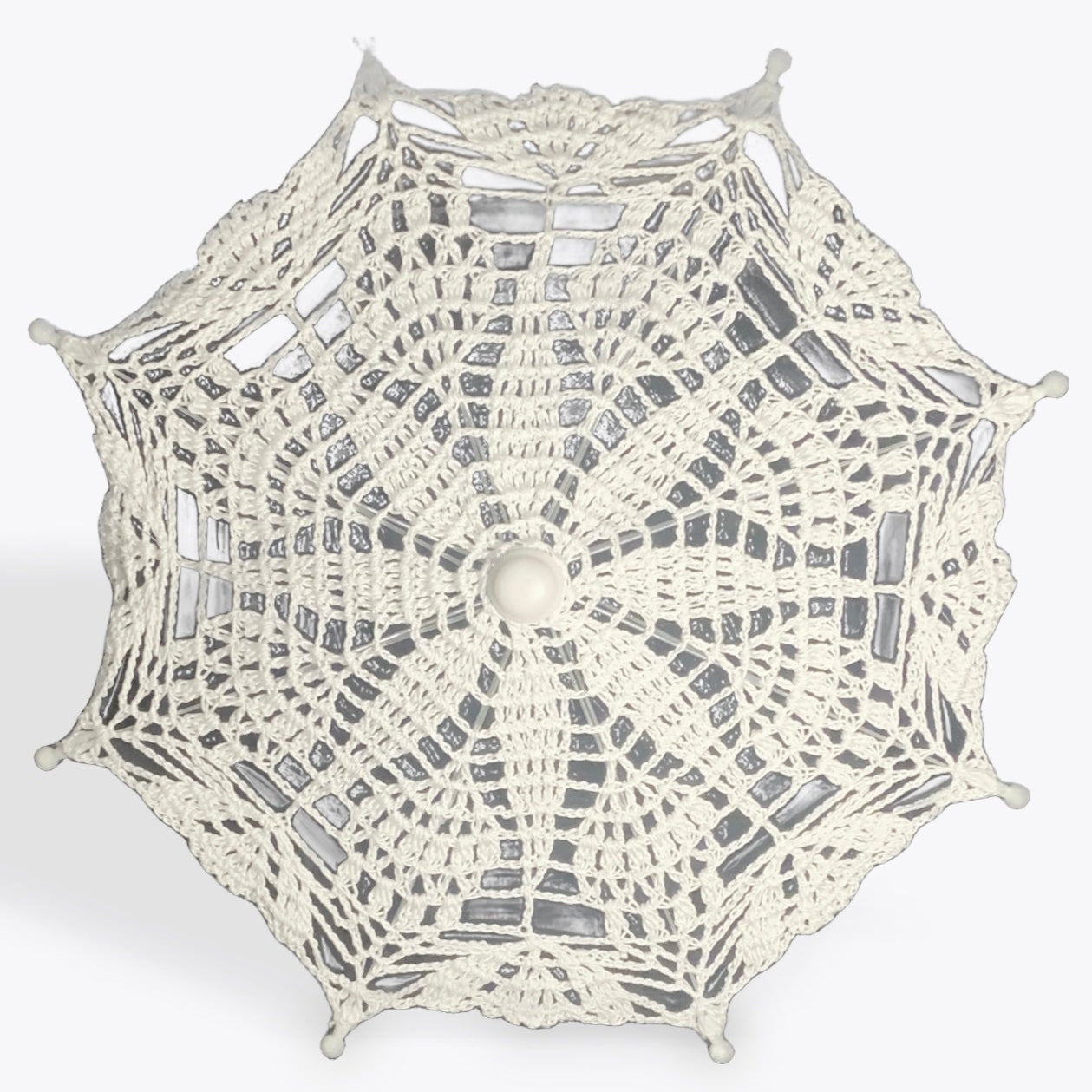 A crochet mandala of white 100% cotton is mounted on a metal parasol frame with white plastic details.