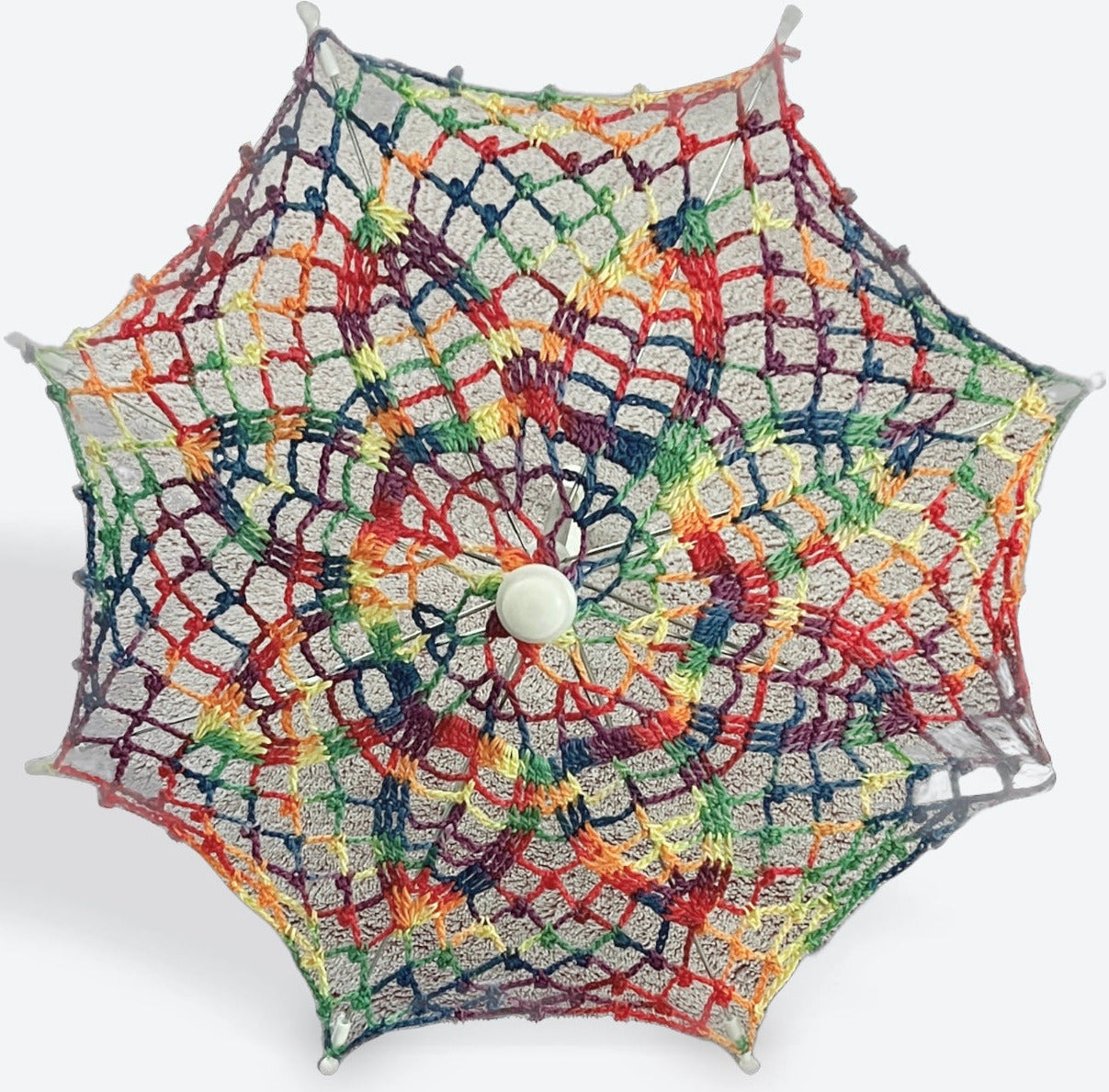 A 12" parasol is open and facing the camera. The canopy is crochet in rainbow variegated yarn and there are lots of rainbows packed in to this daisy pattern. 